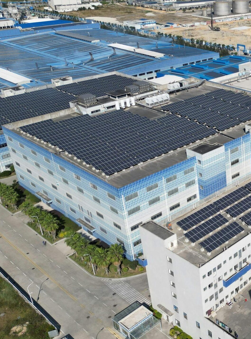 Aerial shot of industrial buildings with solar panels showcases sustainable energy.